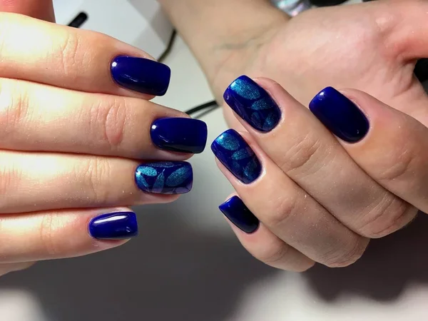 fashionable blue manicure with shiny feathers on square nails