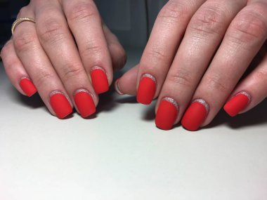 Gümüş ile dokusal bir arka plan üzerinde şık kırmızı mat manikür