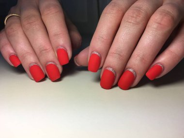 Gümüş ile dokusal bir arka plan üzerinde şık kırmızı mat manikür