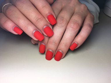 Gümüş ile dokusal bir arka plan üzerinde şık kırmızı mat manikür