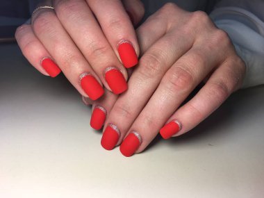 Gümüş ile dokusal bir arka plan üzerinde şık kırmızı mat manikür