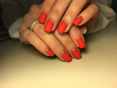 Gümüş ile dokusal bir arka plan üzerinde şık kırmızı mat manikür