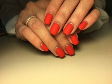 Gümüş ile dokusal bir arka plan üzerinde şık kırmızı mat manikür