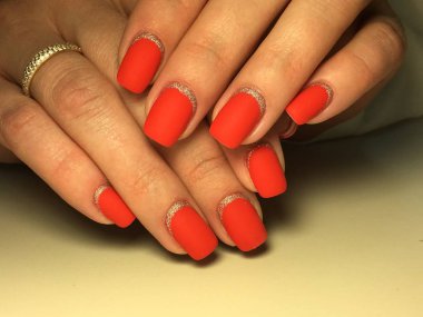 Gümüş ile dokusal bir arka plan üzerinde şık kırmızı mat manikür