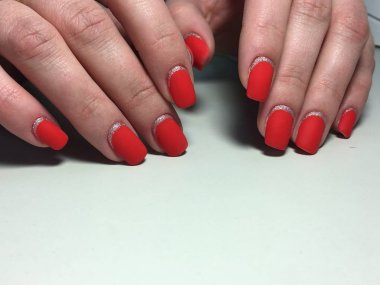 Gümüş ile dokusal bir arka plan üzerinde şık kırmızı mat manikür