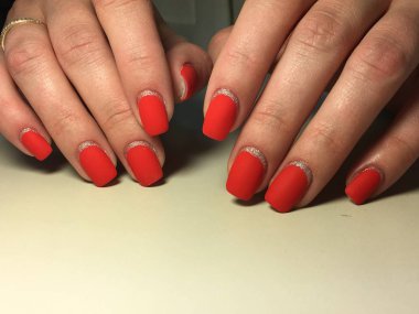 Gümüş ile dokusal bir arka plan üzerinde şık kırmızı mat manikür