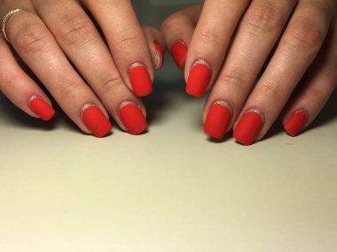 Gümüş ile dokusal bir arka plan üzerinde şık kırmızı mat manikür