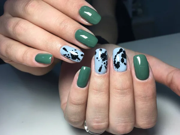 trendy green manicure on a textural background