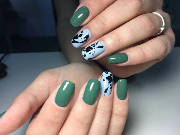 trendy green manicure on a textural background