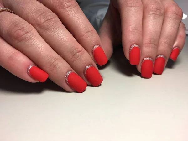 Modieuze rode matte manicure op een texturale achtergrond met zilver — Stockfoto