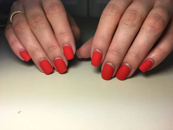 Manicure matte vermelho na moda em um fundo textural com prata — Fotografia de Stock