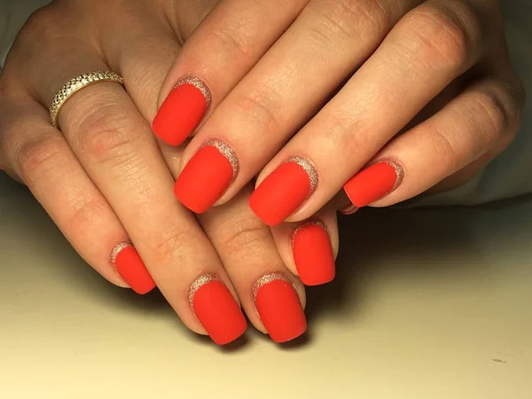 Manicure matte vermelho na moda em um fundo textural com prata — Fotografia de Stock