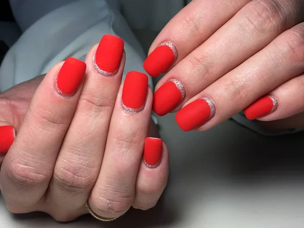 Fashionable red matte manicure on a textural background with silver — Stock Photo, Image