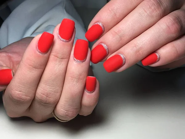 Manicure matte vermelho na moda em um fundo textural com prata — Fotografia de Stock