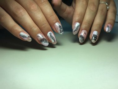 Beyaz gümüş ve yapraklı şık hafif manikür.