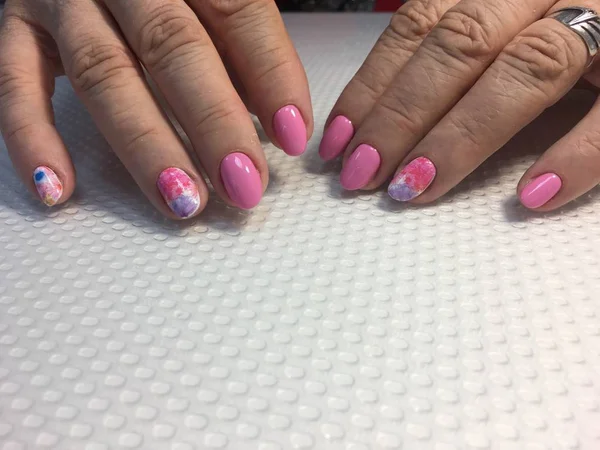 fashionable pink manicure with multi-colored design on long nails