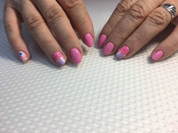 Trendy roze manicure met veelkleurige ontwerp op lange nagels — Stockfoto