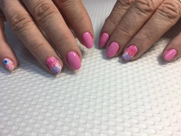 Trendy roze manicure met veelkleurige ontwerp op lange nagels — Stockfoto