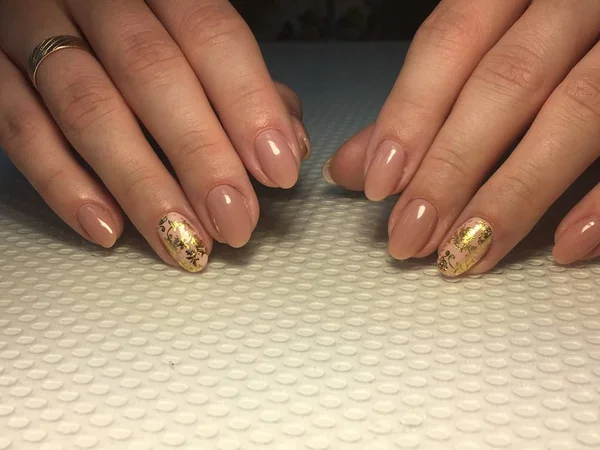 Altın folyo desenli süper bej manikür.