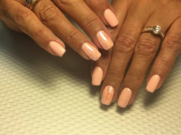 Zacht licht roze manicure trendy roze koraal manicure met folie ontwerp op een gestructureerde achtergrond — Stockfoto