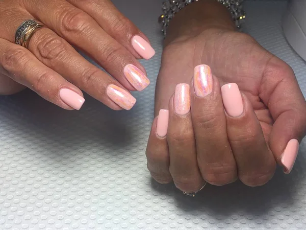 Zacht licht roze manicure trendy roze koraal manicure met folie ontwerp op een gestructureerde achtergrond — Stockfoto