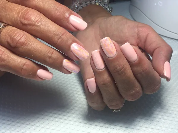 Zacht licht roze manicure trendy roze koraal manicure met folie ontwerp op een gestructureerde achtergrond — Stockfoto