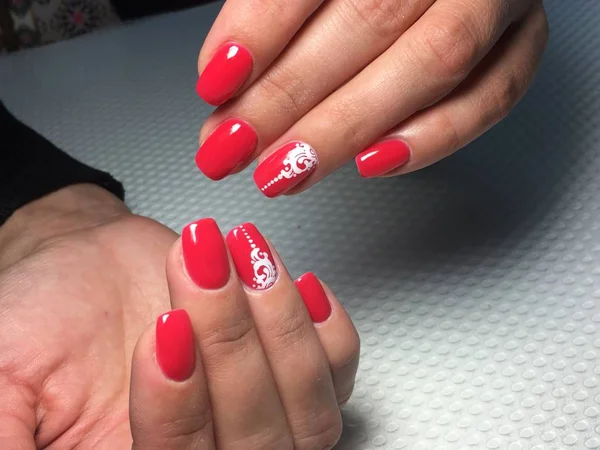 Manicure vermelho na moda com padrão de renda branca — Fotografia de Stock