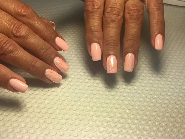 Zacht licht roze manicure trendy roze koraal manicure met folie ontwerp op een gestructureerde achtergrond — Stockfoto