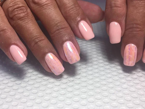 Manicure rosa chiaro delicato alla moda manicure corallo rosa con disegno foglio su uno sfondo strutturato — Foto Stock