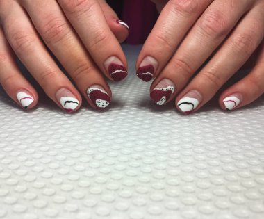 Beyaz ve bordo tasarımlı modaya uygun bir manikür.,