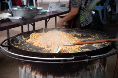 Taze pişmiş Pad Thai büyük bir demir tavada.