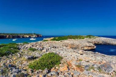 Kayalık sahil şeridine Mallorca güzel turkuaz su ve yatlar bir koyda