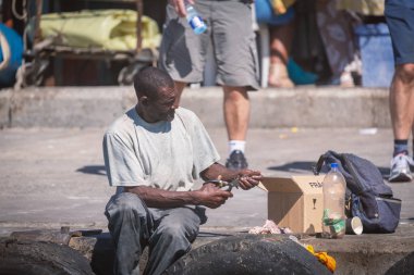Cape Town, Güney Afrika - Kasım, 2018: iskelede oturup ve besleme Afrika adam Hout Bay, Cape Town mühürler.