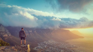 Güzel bir günbatımı manzarası ile Cape Town aslan'ın baş dağın tepesine kenarında duran genç adam