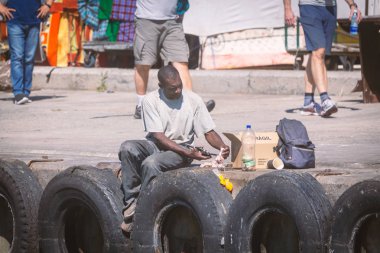 Cape Town, Güney Afrika - Kasım, 2018: iskelede oturup ve besleme Afrika adam Hout Bay, Cape Town mühürler.