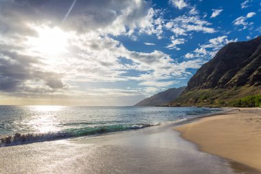 Makua beach, Oahu, Hawaii bulutlara throug parlayan güneş ile akşam görünümü