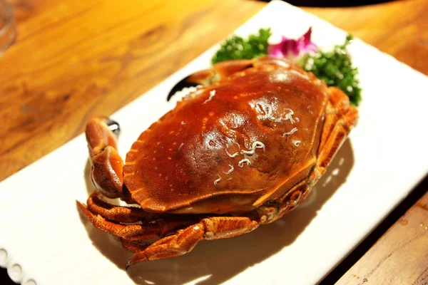 Big crab with herbs on a white plate