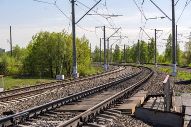 Demiryolu keskin bir dönüş. Üç yolu. Elektrikli tellerle direkleri.