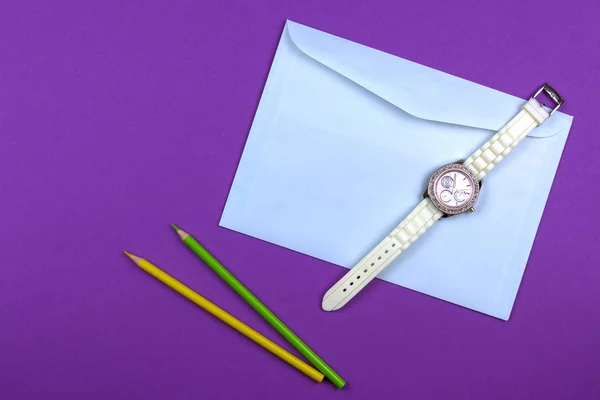 Sobre Dos Lápices Reloj Mujer Sobre Fondo Púrpura —  Fotos de Stock