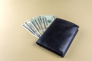 20 ve 100 doları faturalarında bej renkli bir arka plan ve bir siyah erkek cüzdan. Nakit