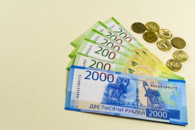 Rus nakit. Banknot olarak iki bin ruble. Bej renkli arka plan üzerinde birkaç sikke.