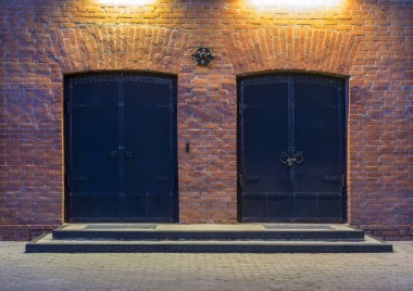 Gece görünümü. Endüstriyel bina. İki büyük bir kırmızı tuğla bina kapıları metal. Ambar girişi.