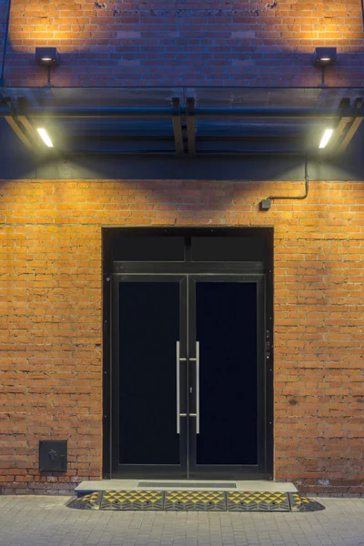 Night view. Industrial building. Large doors in a red brick building. The entrance to the office.
