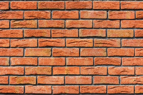 Red brick wall. Decorative brick with artificial defects and cracks. Background