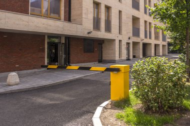 Avlunun bir ofis binası girişinde. Girmeden önce sarı kapı. Kırmızı tuğla duvarım evin.