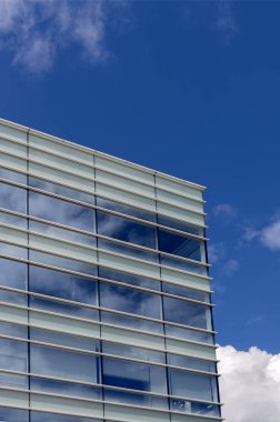 Mavi gökyüzüne karşı Cam ofis binası yapılmış.