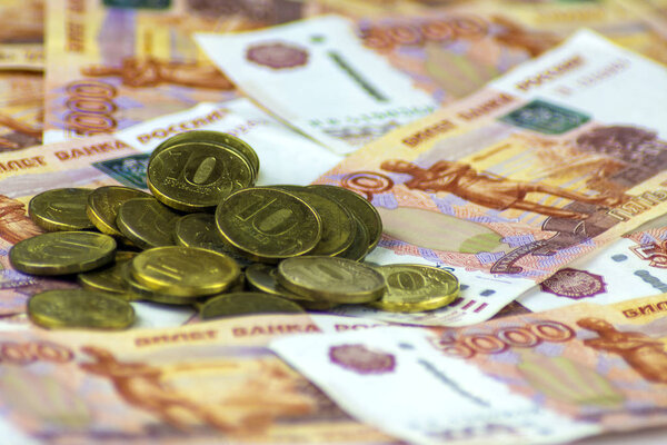 Русские деньги. Банкноты по 5000 рублей. Разбросанные монеты
