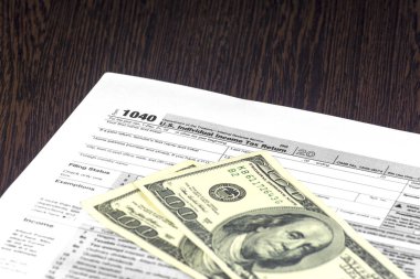 Amerikan vergi form 1040 tablodur. Birkaç fatura üsttedir. Nakit olarak 100 Usd