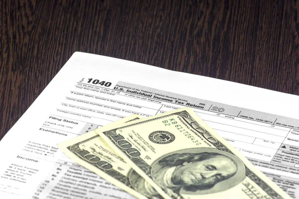 Amerikan vergi form 1040 tablodur. Birkaç fatura üsttedir. Nakit olarak 100 Usd