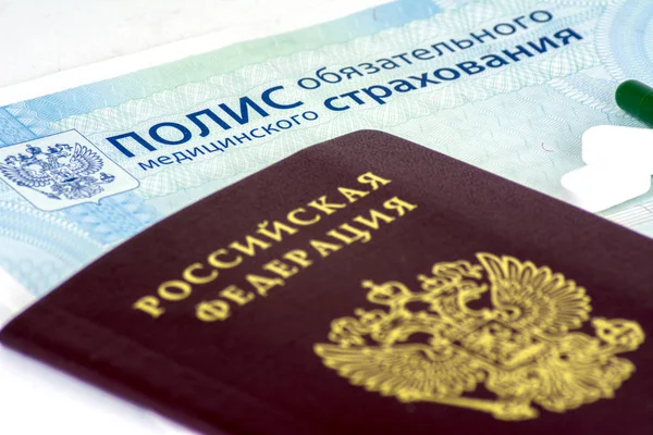 俄罗斯健康保险政策和俄罗斯护照和一些蓝色背景药片特写 — 图库照片